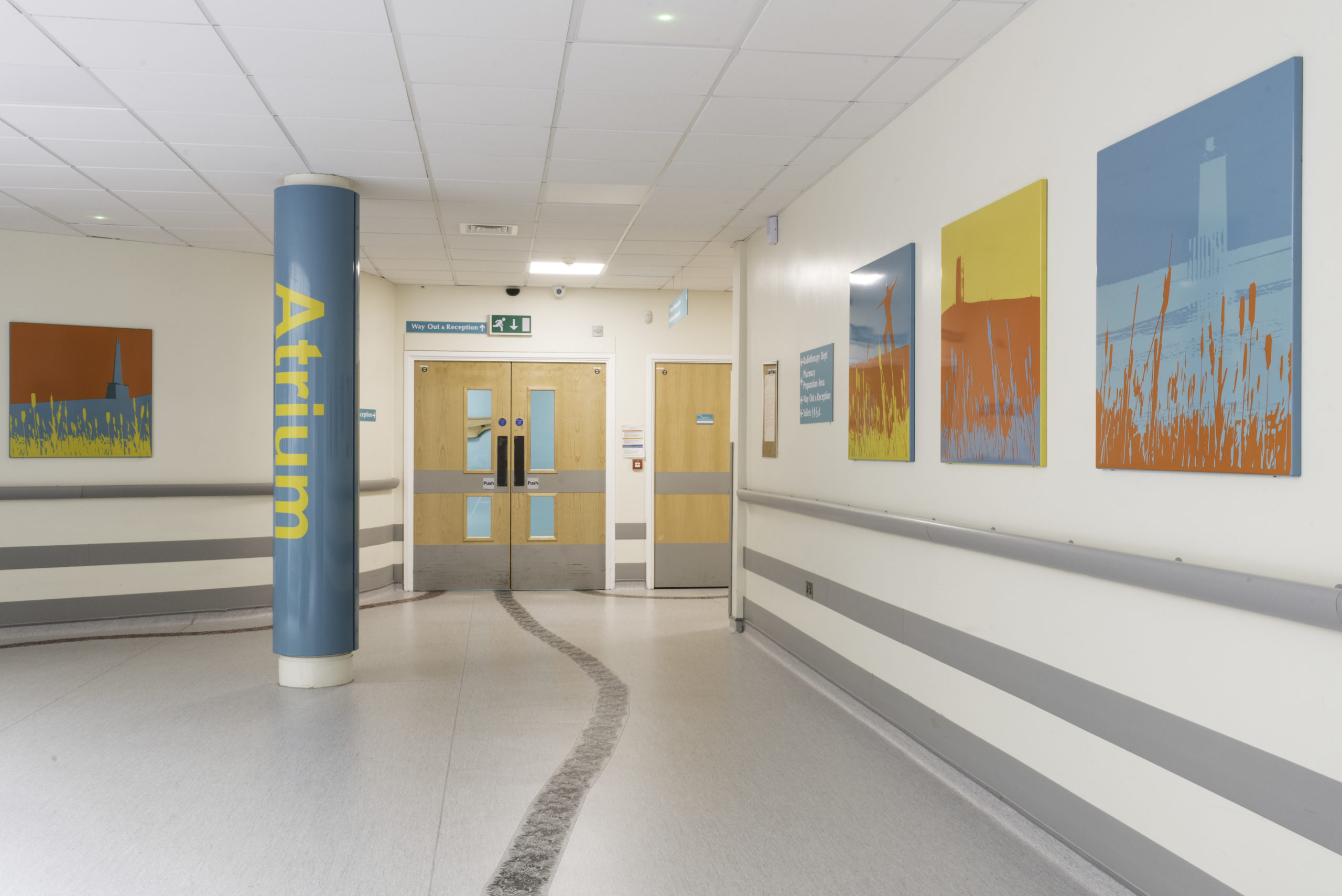 The Atrium corridor with several art prints hung up on the wall