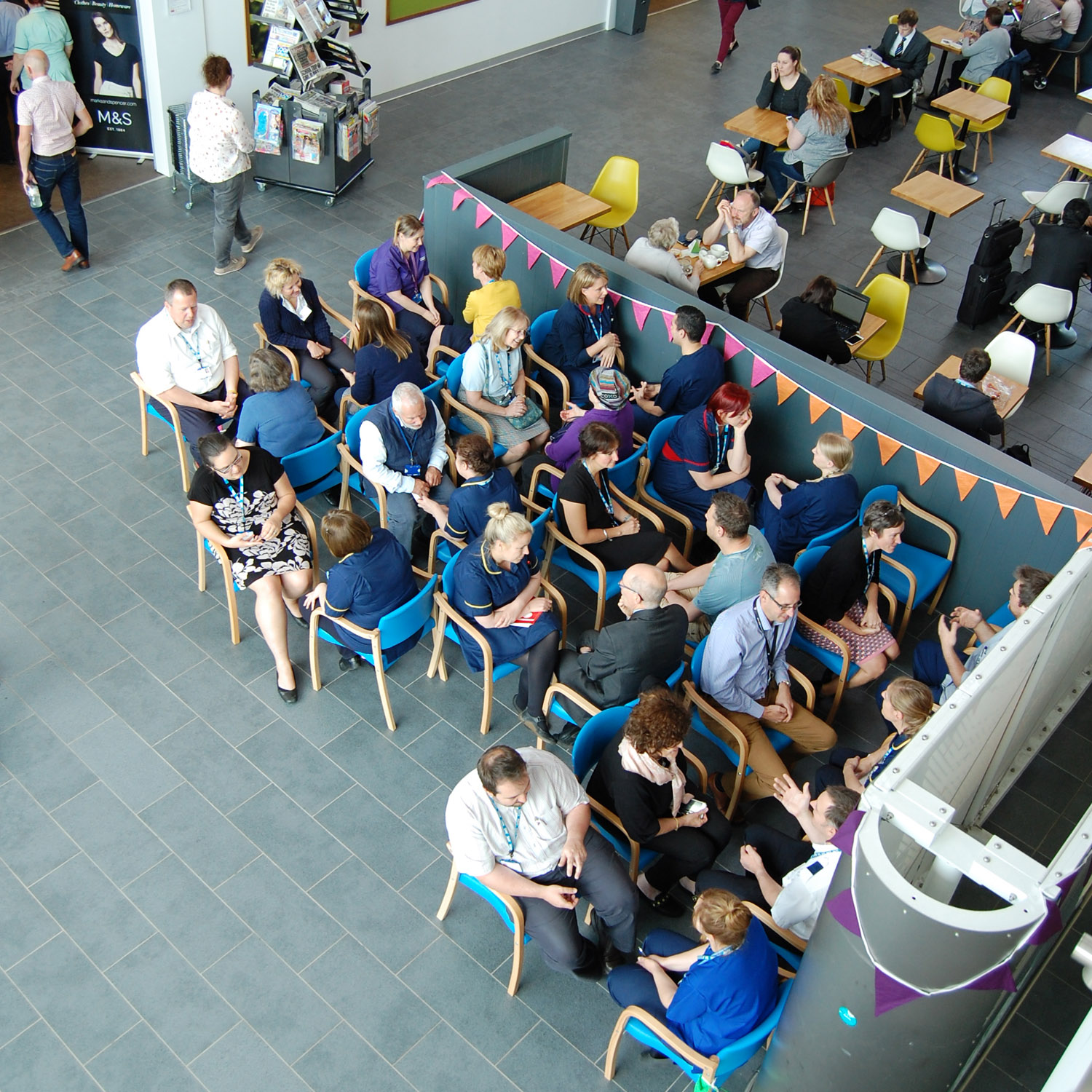 A number of people sitting close to each other and having conversations with each other