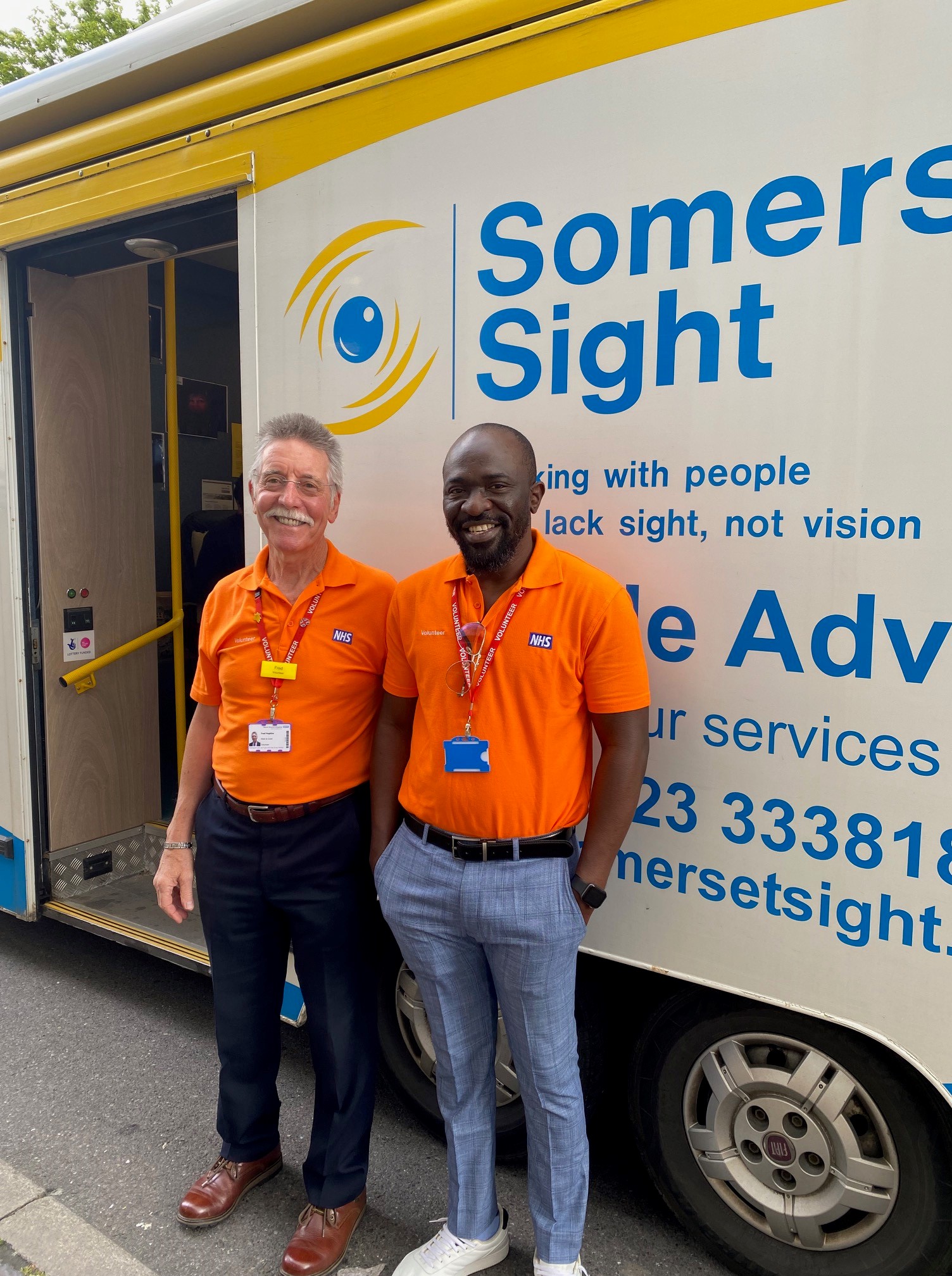 Two volunteers stood infront of the Somerset Sight van that travels around Somerset.