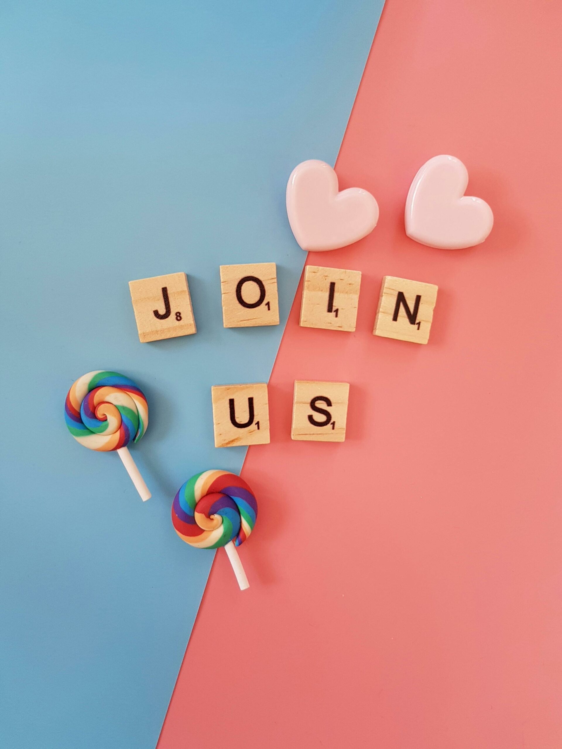 join us written in wooden letters on a blue and pink back ground and with two lollipops next to the words